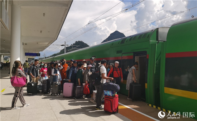 乘坐中老鐵路國(guó)際旅客列車的旅客在老撾瑯勃拉邦站排隊(duì)上車。人民網(wǎng)記者 杜明明攝