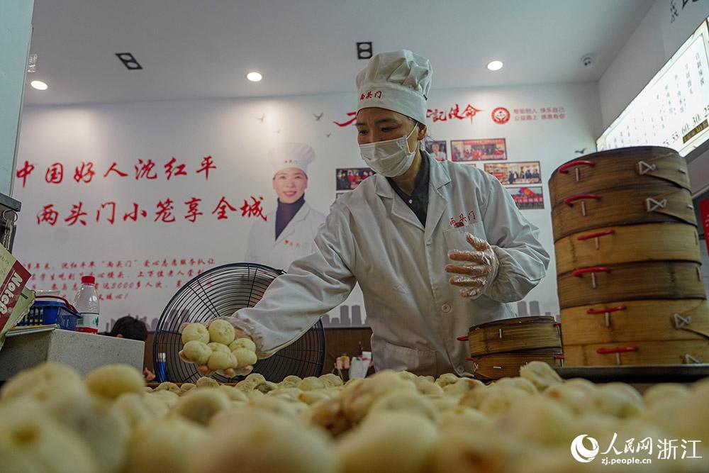 3月31日，在浙江省嵊州市甘霖鎮(zhèn)，嵊州小吃從業(yè)者沈紅平把蒸熟的小籠包晾涼，打包冷藏售賣。人民網(wǎng) 章勇濤攝