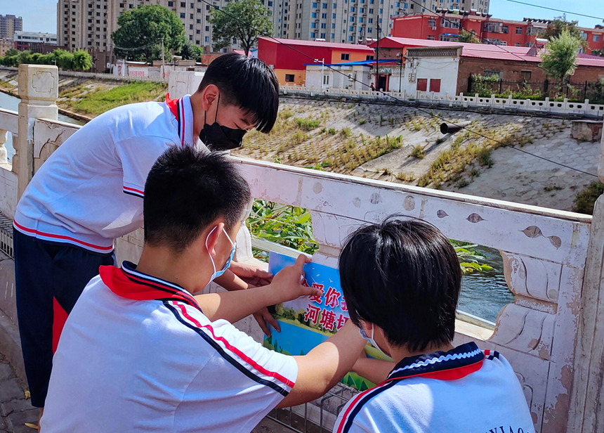 徐水小學(xué)學(xué)雷鋒志愿者在瀑河河邊張貼防溺水警示標(biāo)語。 徐水區(qū)委宣傳部供圖