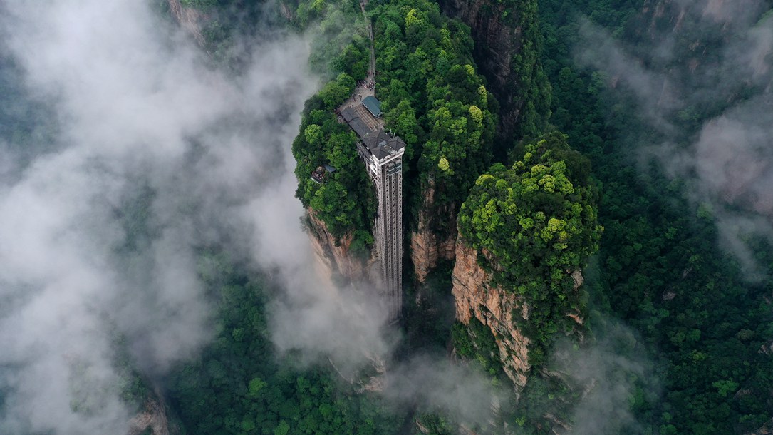 位于張家界武陵源景區(qū)的百龍?zhí)焯蓁偳对谠旗F繚繞的峰林間，雄偉壯觀。吳勇兵攝