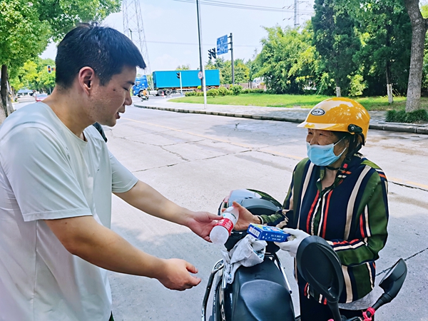 何超為過路的老人送上礦泉水和冷飲。人民網(wǎng)記者 王繼亮攝