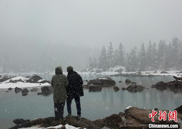 游客欣賞雪中然烏湖。　冉文娟 攝