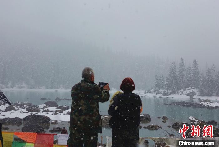 游客欣賞雪中然烏湖。　冉文娟 攝