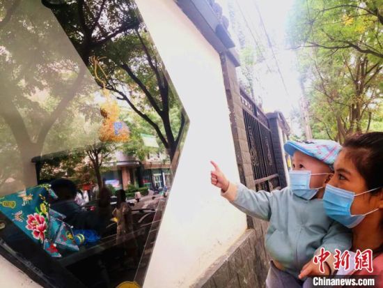 圖為蘭州市民在街頭觀賞刺繡和刻葫蘆的非遺展示。(資料圖) 史靜靜 攝