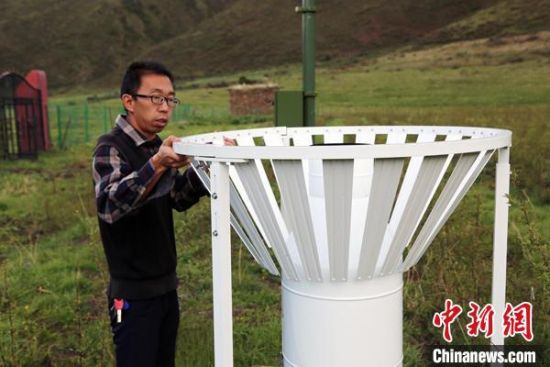 圖為班瑪縣氣象局工作人員在維護藏雪茶基地氣候站。青海省氣象局供圖