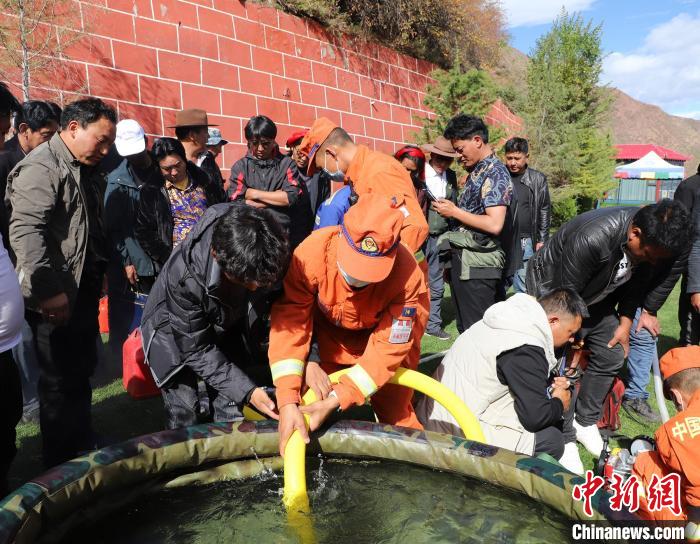 圖為森林消防員為護(hù)林員講解滅火裝備的使用方法。　昌都市森林消防支隊(duì) 供圖