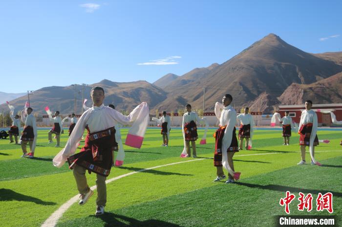 圖為青海師范大學(xué)附屬玉樹實(shí)驗(yàn)學(xué)校學(xué)生在綠茵場(chǎng)跳起囊謙古舞—卓根瑪。　程雨 攝