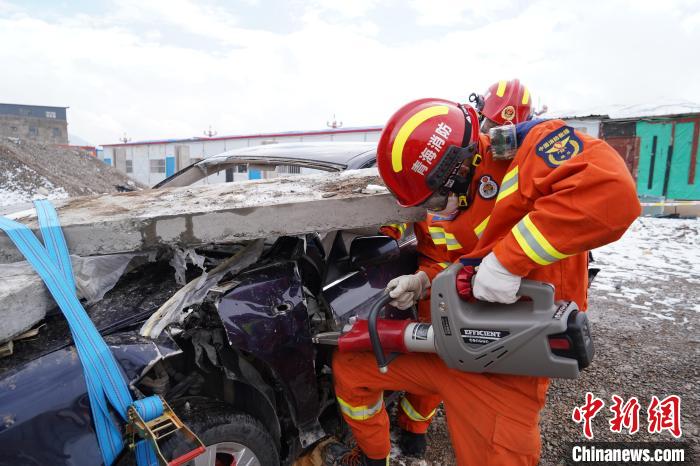 圖為地震實戰(zhàn)拉動現(xiàn)場，參演人員進行車輛破拆?！∮駱湎拦﹫D