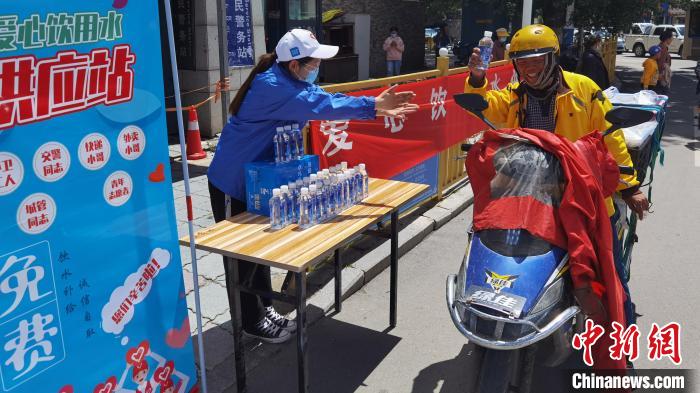 圖為近日，西藏自治區(qū)青年志愿者協(xié)會(huì)志愿者在拉薩街頭向快遞員送水。西藏自治區(qū)青年志愿者協(xié)會(huì) 供圖