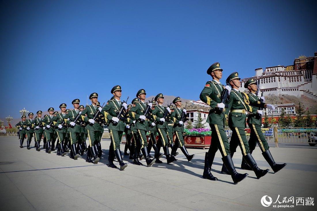 國旗護衛(wèi)隊隊員緊握鋼槍，踏著威武雄壯的步伐，走向國旗臺。人民網(wǎng) 次仁羅布攝