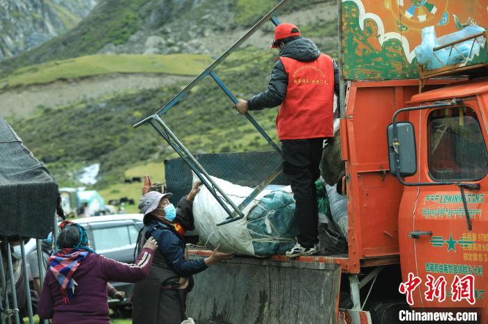 圖為工作人員幫助牧民們卸家具?！÷蹇?攝