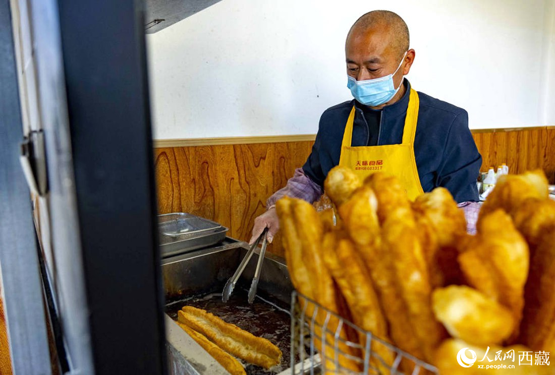 早餐店老板正在炸油條。人民網(wǎng) 次仁羅布攝