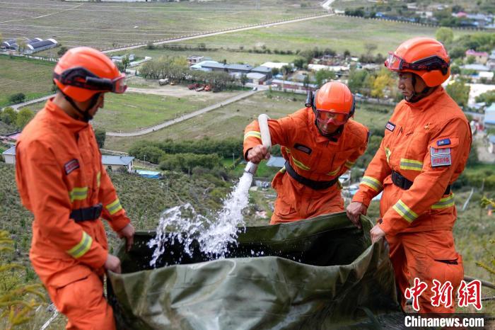 技能大練兵過程中，消防員在陡坡上向蓄水池注水?！±顕鵂c 攝