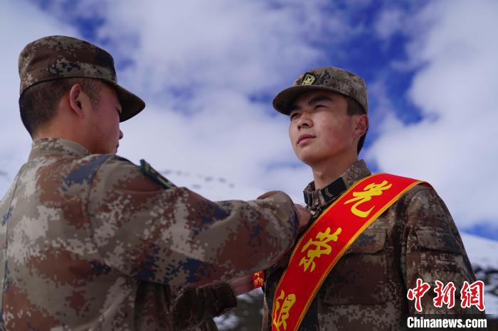 排長王朝偉(圖左)給退伍老兵佩戴大紅花。　西藏山南軍分區(qū)某團(tuán)供圖