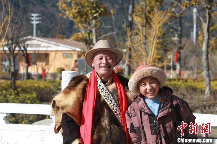 圖為林芝市巴宜區(qū)布久鄉(xiāng)仲果村村民桑杰與孫子一起參加藏歷新年活動?！埩?攝