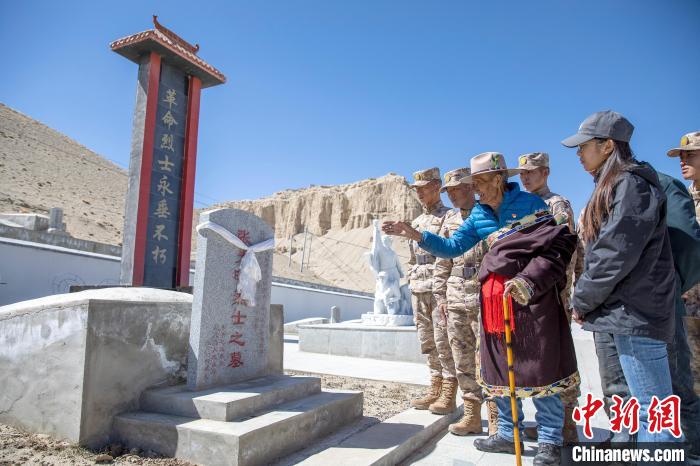 圖為在西藏阿里地區(qū)札達縣烈士陵園，82歲的次仁南杰老人為軍民代表講述新舊西藏的變化?！詵| 攝