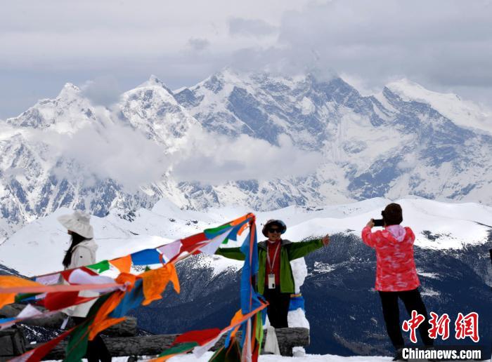 圖為5月14日，西藏林芝色季拉山觀景臺，游客與南迦巴瓦峰合影。　李林 攝