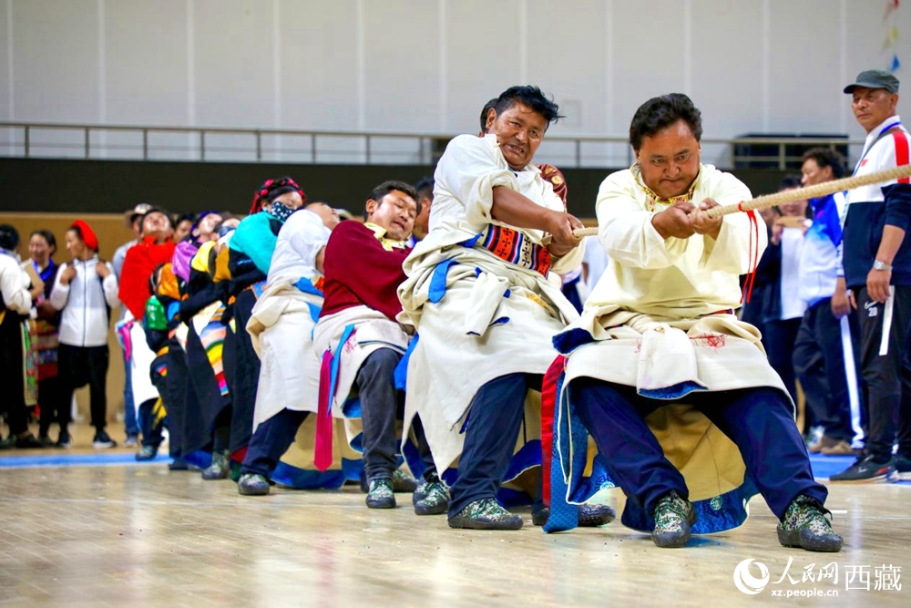 身著民族服裝的農(nóng)牧民選手在拔河比賽現(xiàn)場。